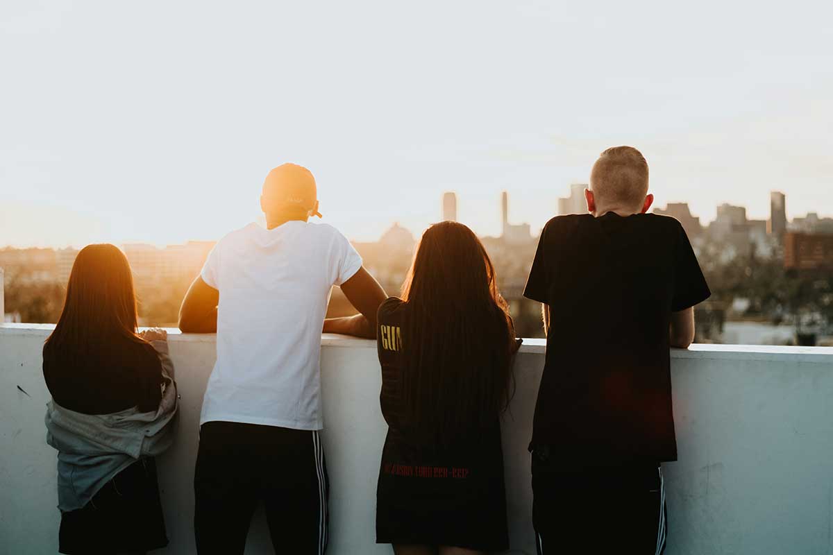 Four youth looking out over a city